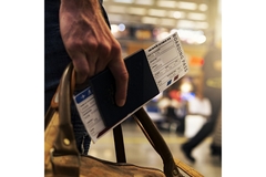 Image Person holding an airplane ticket.